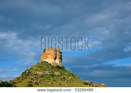 Sandstone buttress against a dark blue sky with thunder clouds, South Africa