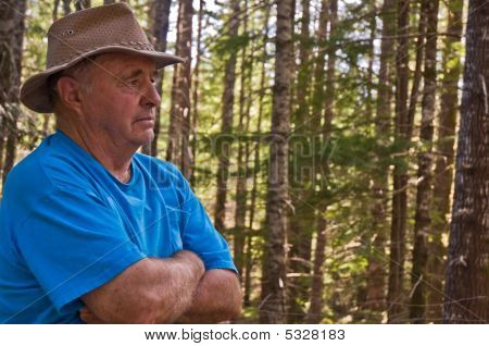 Senior male profile thinking in the woods