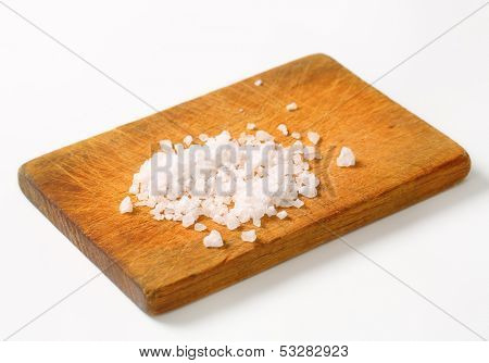 portion of crystal salt on a wooden cutting board