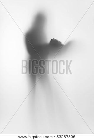 Human standing female body silhouette with book behind a curtain