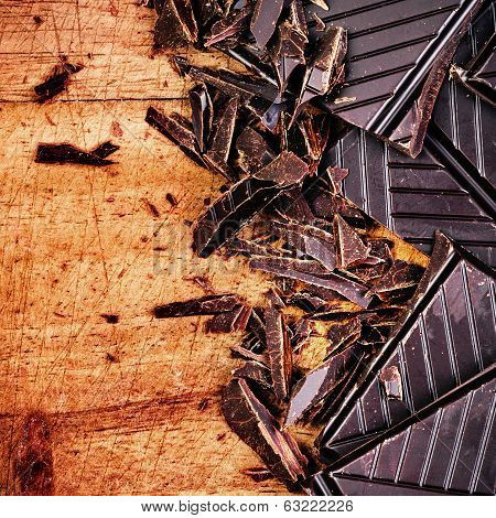 Chopped Chocolate Bar On Wooden Background Closeup. Chunks Of Broken Dark Chocolate Bar On Wood Tabl
