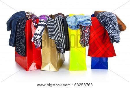 color shopping bags with clothing isolated on white with reflection