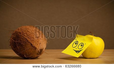 Apple with sticky post-it note reacting to coconut