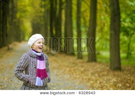 mladá pěkná blondýnka stojí v krásném parku baví