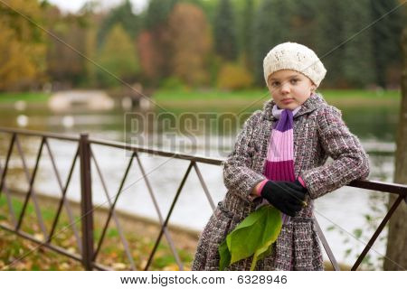 šťastná mladá dívka s překříženýma rukama před stojící nedaleko plotu
