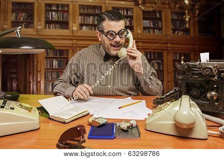 Employee with glasses talking on the phone in the office