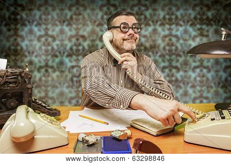 Employee with glasses talking on the phone in the office