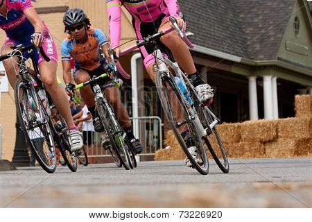 Low-angle View Of Female Cyclists Leaning Into Turn
