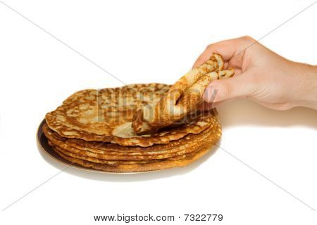 La plaque de crêpes russes et de la main de l'homme