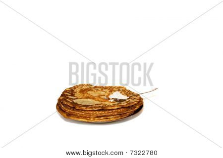 Crêpes russes et la cuillère avec la crème sure