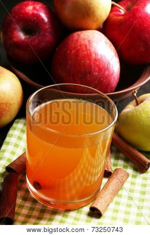 Apple cider with cinnamon sticks and fresh apples on wooden background