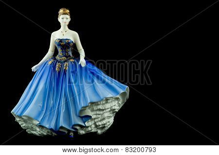 Bone China Figurine wearing a Blue Dress Isolated on a Black Background