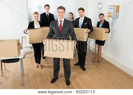 Employees In Office Holding Cardboard Boxes