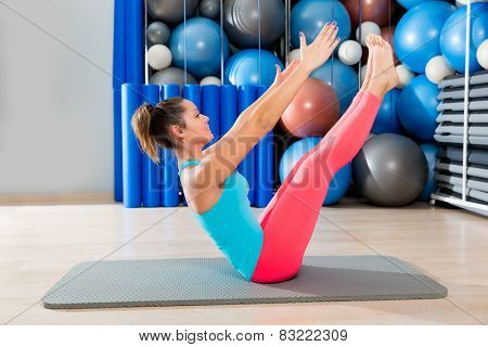 Pilates Teaser exercise woman on mat gym indoor and swiss balls background