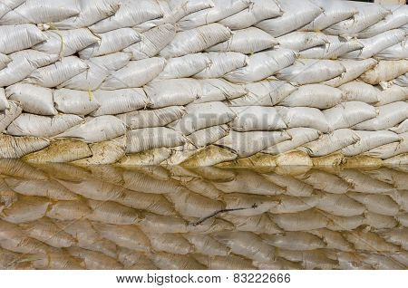 White Sandbags For Flood Defense And It's Reflection Brown Water