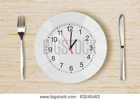 Dinner plate with clock face on wooden table