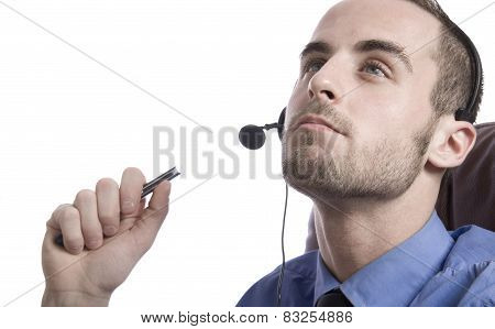 Concentrated young businessman using laptop and phone at office