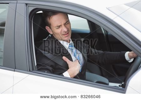 Businessman suffering from heartache in his car