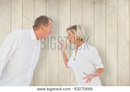 Angry older couple arguing with each other against wooden planks