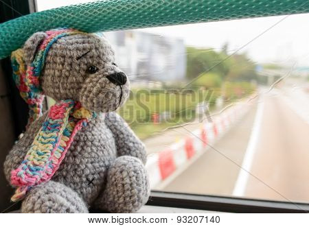 grey knited travel toy bear sit nera window in HongKong bus