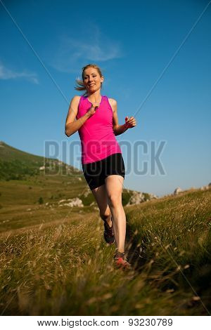 Beautiful Young Woman Runns Cross Country On A Mountian Path At Sunrise