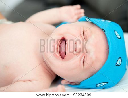 Nice newborn in diaper crying inconsolably