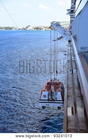 CAYMAN ISLANDS - DEC 30, 2014: Holland American Line Cruise ship Zuiderdam anchor offshore in George Town, Cayman Islands. The tender is being winched down to the seas.