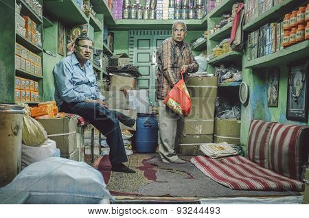 JODHPUR, INDIA - 07 FEBRUARY 2015: Shop owner waiting while customer looks for goods to buy. Shop owners also stay in stores until late working hours.Post-processed with added grain and texture.