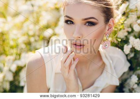 Beautiful happy woman in a flowery spring garden.