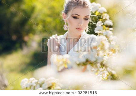 Beautiful happy woman in a flowery spring garden.