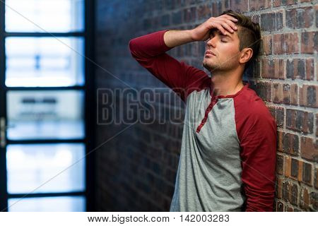 Stressed man suffering from headache in building