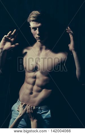 Sexy male torso with female hands on muscular body of young man