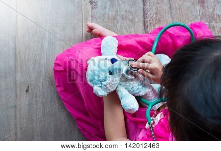 Top View Of Child Playing Doctor Or Nurse With Plush Toy Bear At Home.