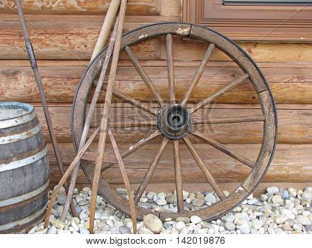 old cartwheel leaning against a wooden wall