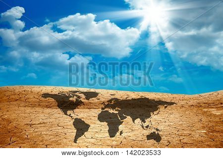 conceptual image of world map on dried cracked landscape over sky. Furnished NASA image used for this image.