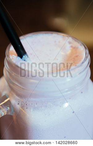 Refreshing blueberry milkshake in a glass. Milkshake closeup view.