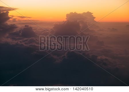 Photo of the Unreal sunrise over dark clouds through window airplane. Soft focus