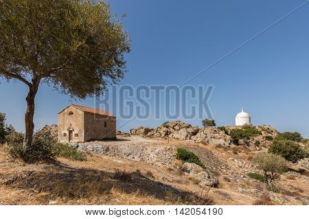 San Sebastiano chapel built in 1819 near Palasca in the Balagne region of Corsica with a large white mausoleum in the background and clear blue sky above