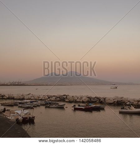 Harbour with boats in front of Mount Vesuvius in a summery sunset