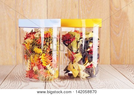 raw fancy pasta of different color in plastic containers