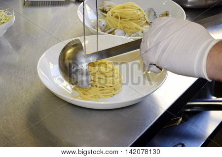 Preparetion dish of spaghetti with clams in a restaurant kitchen