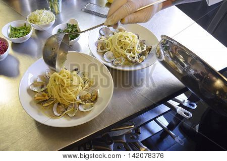 Preparetion dish of spaghetti with clams in a restaurant kitchen