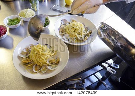 Preparetion dish of spaghetti with clams in a restaurant kitchen