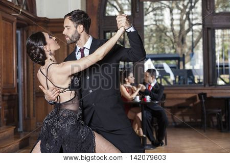 Tango Dancers Performing While Couple Dating In Restaurant