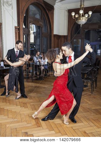 Passionate Dancers Performing Tango While Couple Dating In Resta