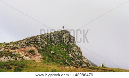 Hiker on the top of rock Chornogora ridge in Carpathians Ukraine