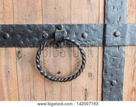 Vintage forged handle gate of the historic fortress. Detail of the doors of the Tikhvin monastery in Russia. Strong ancient building to protect the castle.