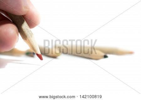 Hand with coloured pencil isolated on white background