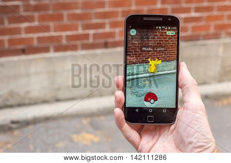Montreal CA - August 10 2016: Closeup of a man playing Pokemon Go on a smart phone. Pokemon Go is a virtual reality game released in July 2016.