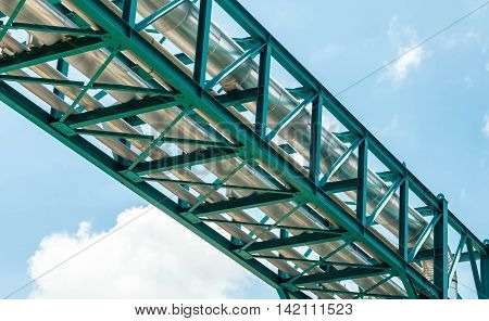 Industrial hose pipe bridge with the sky in the background.